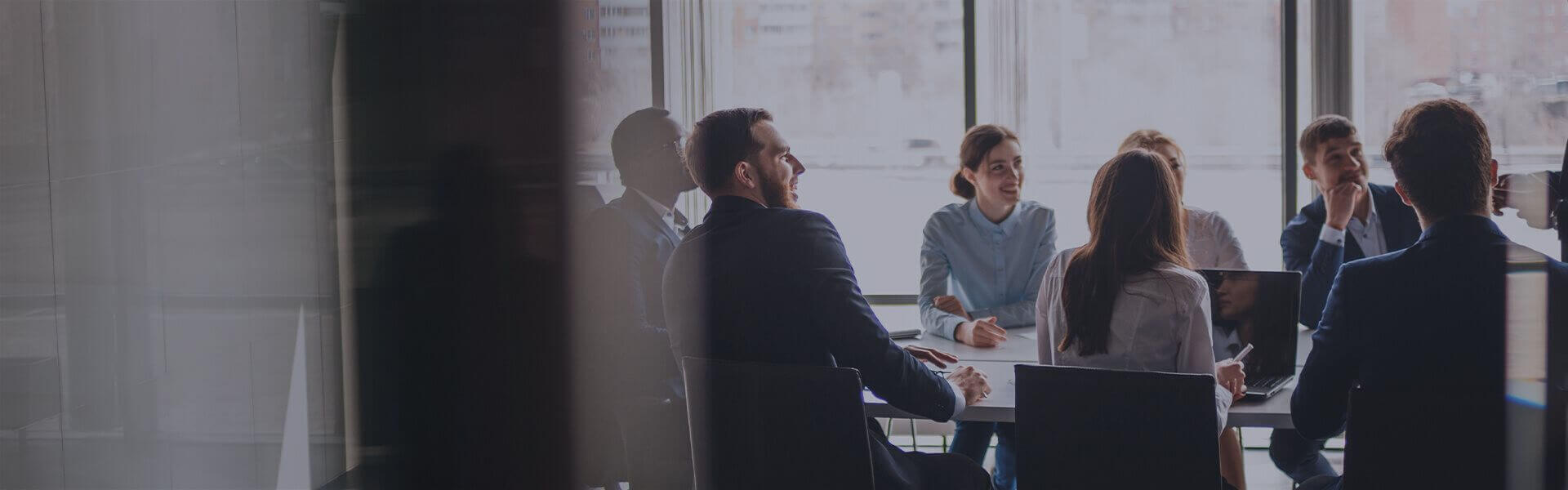 Image of people sat around a table in a meeting room